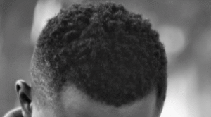 A hi-top fade haircut on male 4C black hair.